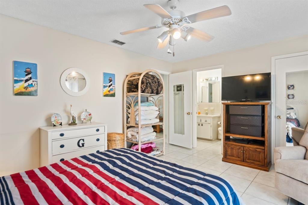 6101 Elmhurst Drive, Unit 5B New Port Richey, FL 34653 - Photo 18 of 45 a bedroom with a bed and a flat tv screen on dresser