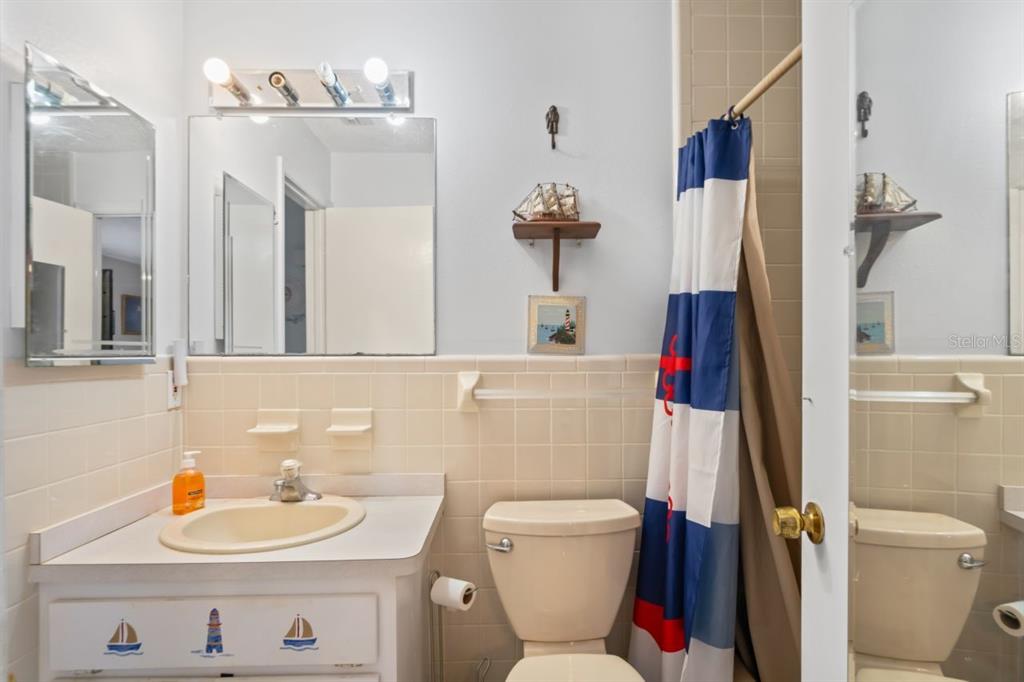 6101 Elmhurst Drive, Unit 5B New Port Richey, FL 34653 - Photo 20 of 45 a bathroom with a sink a toilet and a mirror