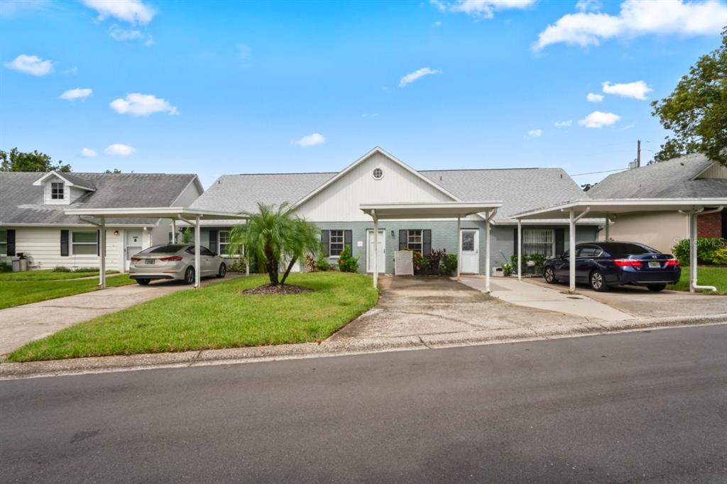 6101 Elmhurst Drive, Unit 5B New Port Richey, FL 34653 - Photo 3 of 45 a front view of a house with a garden and pathway