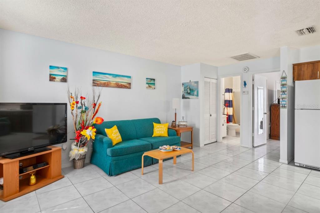 6101 Elmhurst Drive, Unit 5B New Port Richey, FL 34653 - Photo 6 of 45 a living room with furniture and a flat screen tv