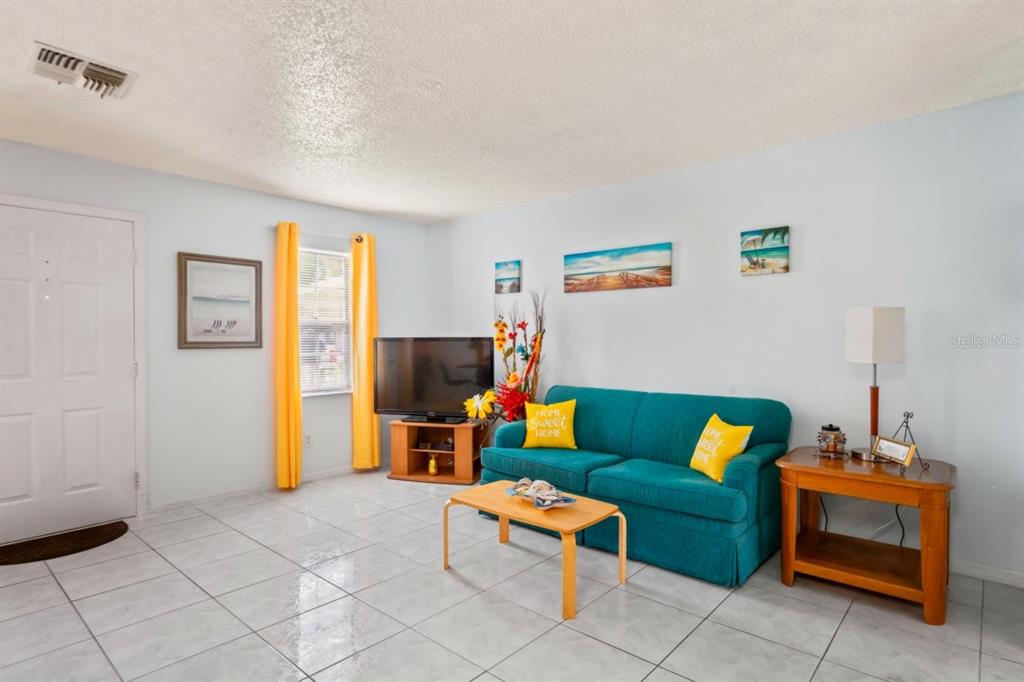 6101 Elmhurst Drive, Unit 5B New Port Richey, FL 34653 - Photo 7 of 45 a living room with furniture and a dining table