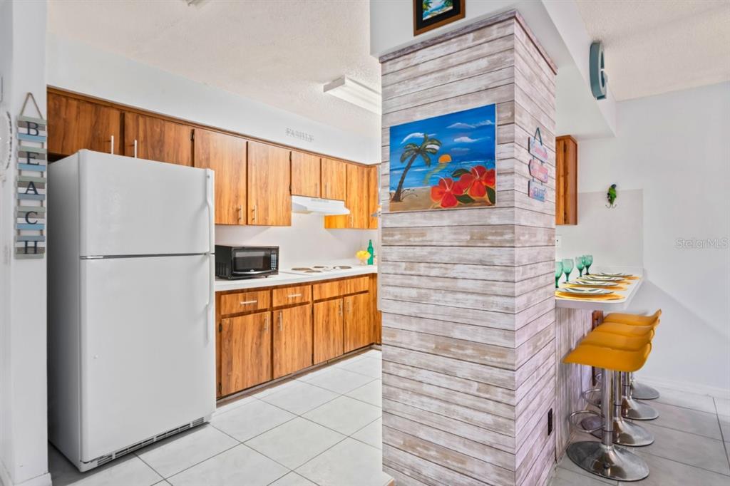 6101 Elmhurst Drive, Unit 5B New Port Richey, FL 34653 - Photo 10 of 45 a kitchen with stainless steel appliances granite countertop a refrigerator and a stove