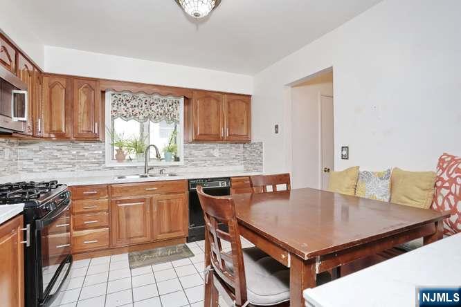 290 Hamilton Place, Unit 4 Hackensack, NJ 07601 - Photo 10 of 50 a kitchen with a kitchen island a stove a table and chairs in it