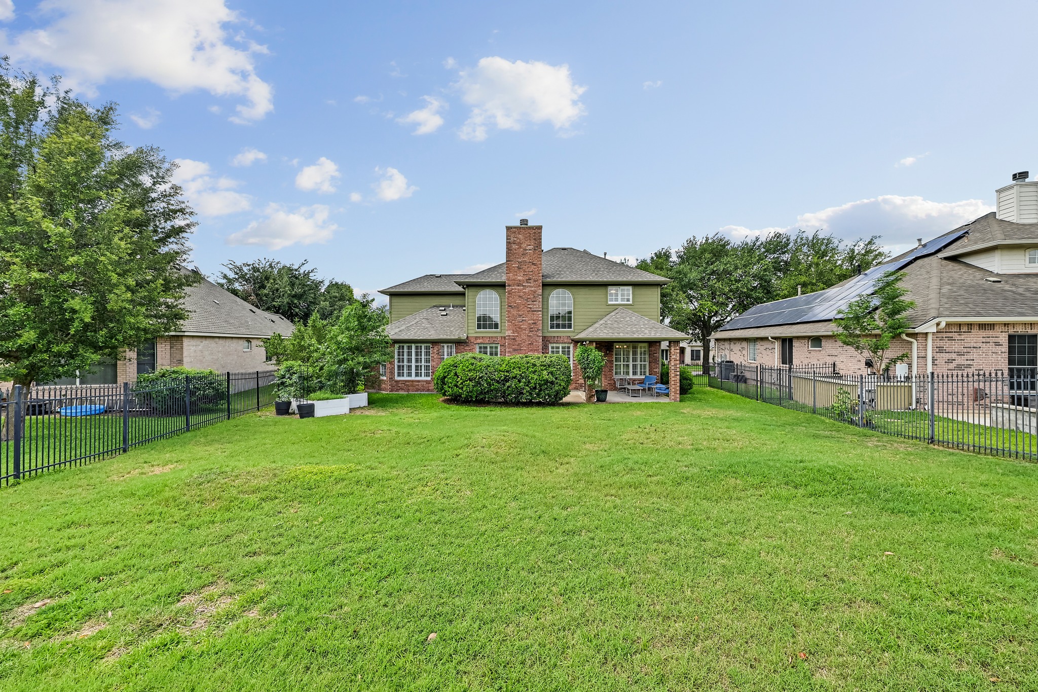 2408 Amen Corner Road Pflugerville, TX 78660 - Photo 38 of 40 Spacious backyard with a large lawn, brick and siding exterior, covered patio, and privacy fencing