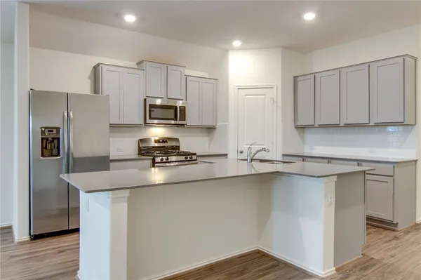 a kitchen with stainless steel appliances a sink stove and refrigerator