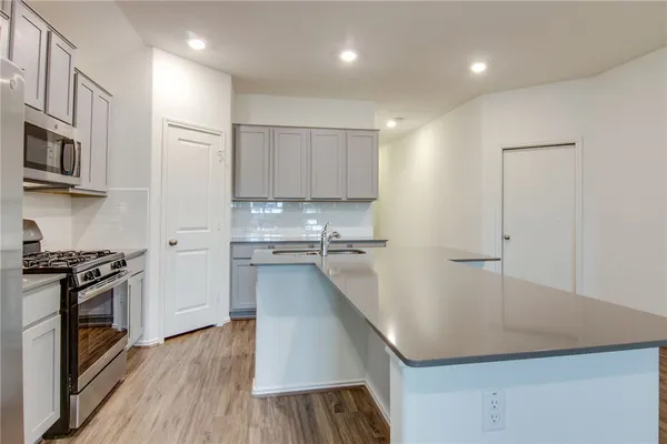 a kitchen with stainless steel appliances a stove a sink a refrigerator and cabinets