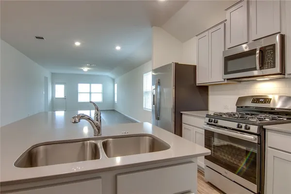 a kitchen with sink a microwave a stove and refrigerator