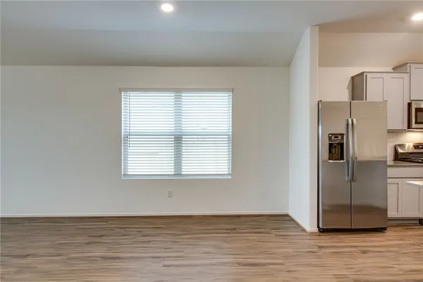 a view of a kitchen with wooden floor electronic appliances and window
