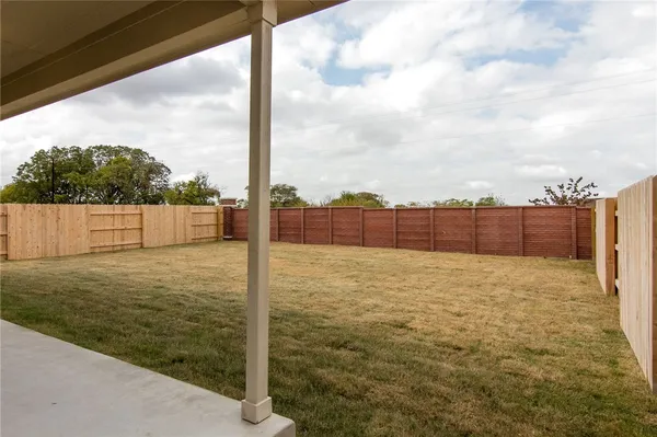 a view of yard with wooden fence