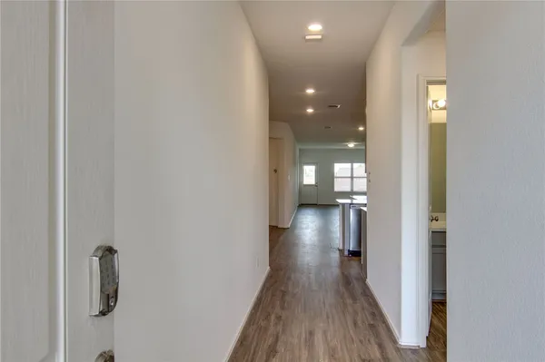 a view of a hallway with wooden floor