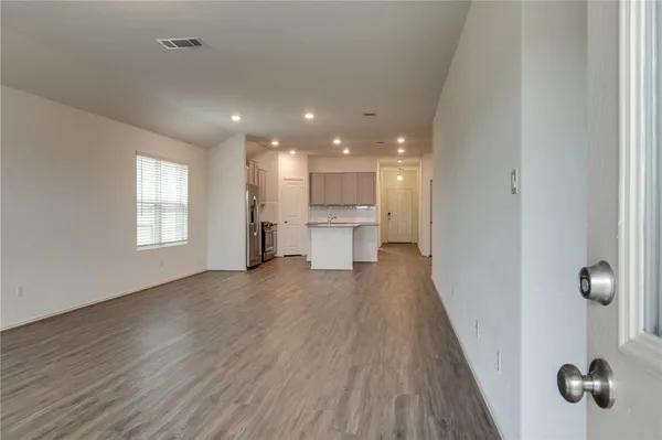 a view of a kitchen with a white wooden floor and stainless steel appliances