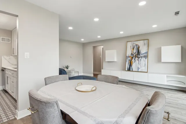 a large white kitchen with sink and a refrigerator