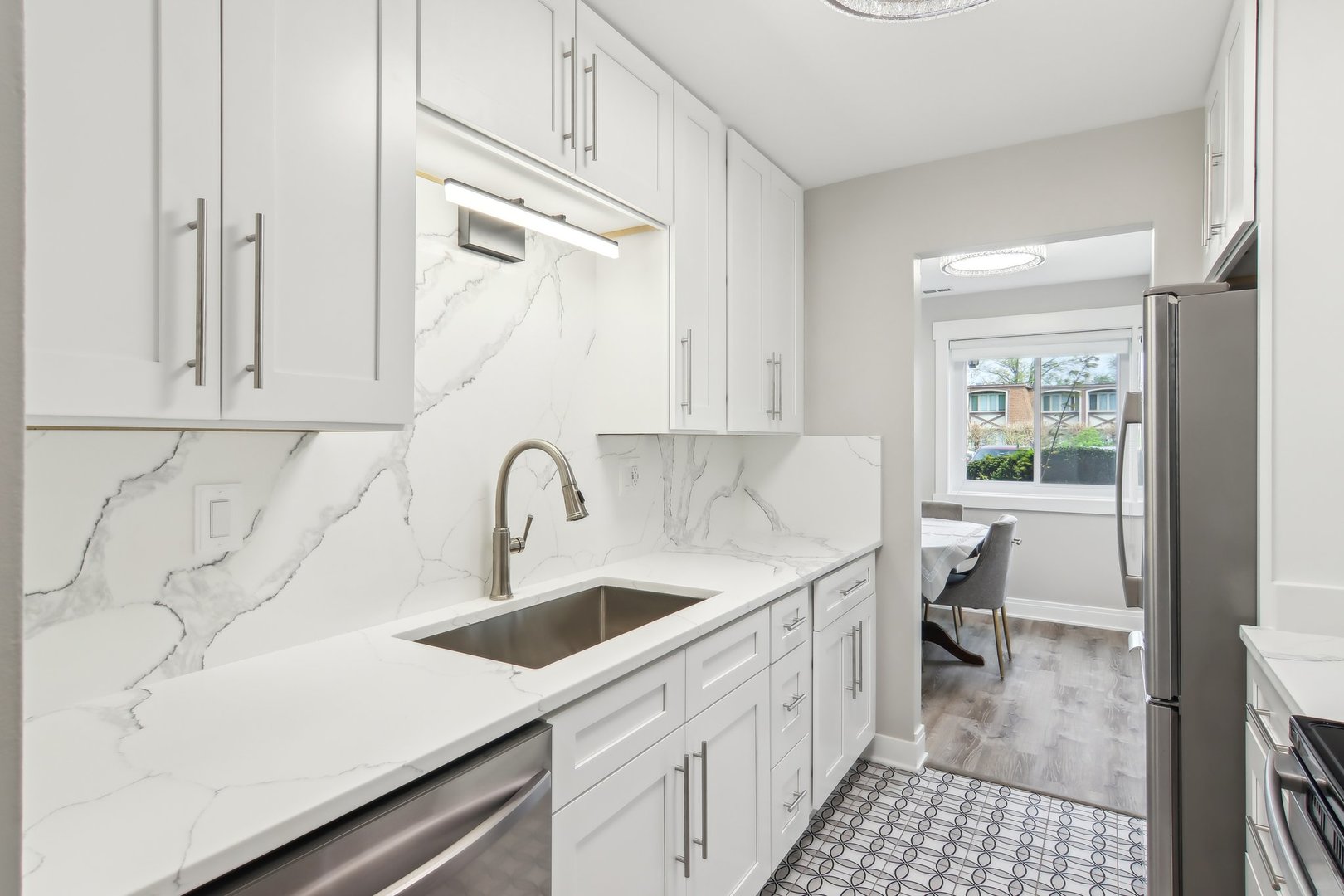 5704 West 128th Street, Unit 1C Crestwood, IL 60418 - Photo 23 of 29 a kitchen with a sink dishwasher and white cabinets with wooden floor