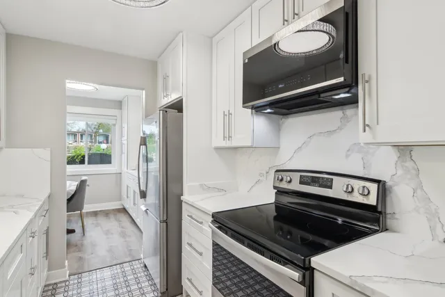 a kitchen with stainless steel appliances a stove a microwave and a refrigerator
