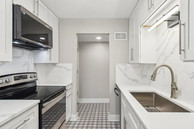 a kitchen with a sink cabinets and stainless steel appliances