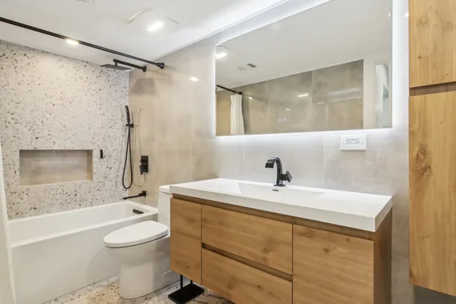 a bathroom with a sink a toilet and shower
