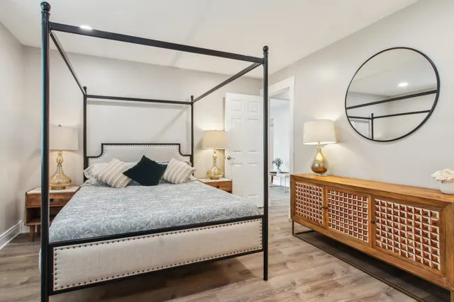 a bedroom with a bed window and a potted plant on the wall