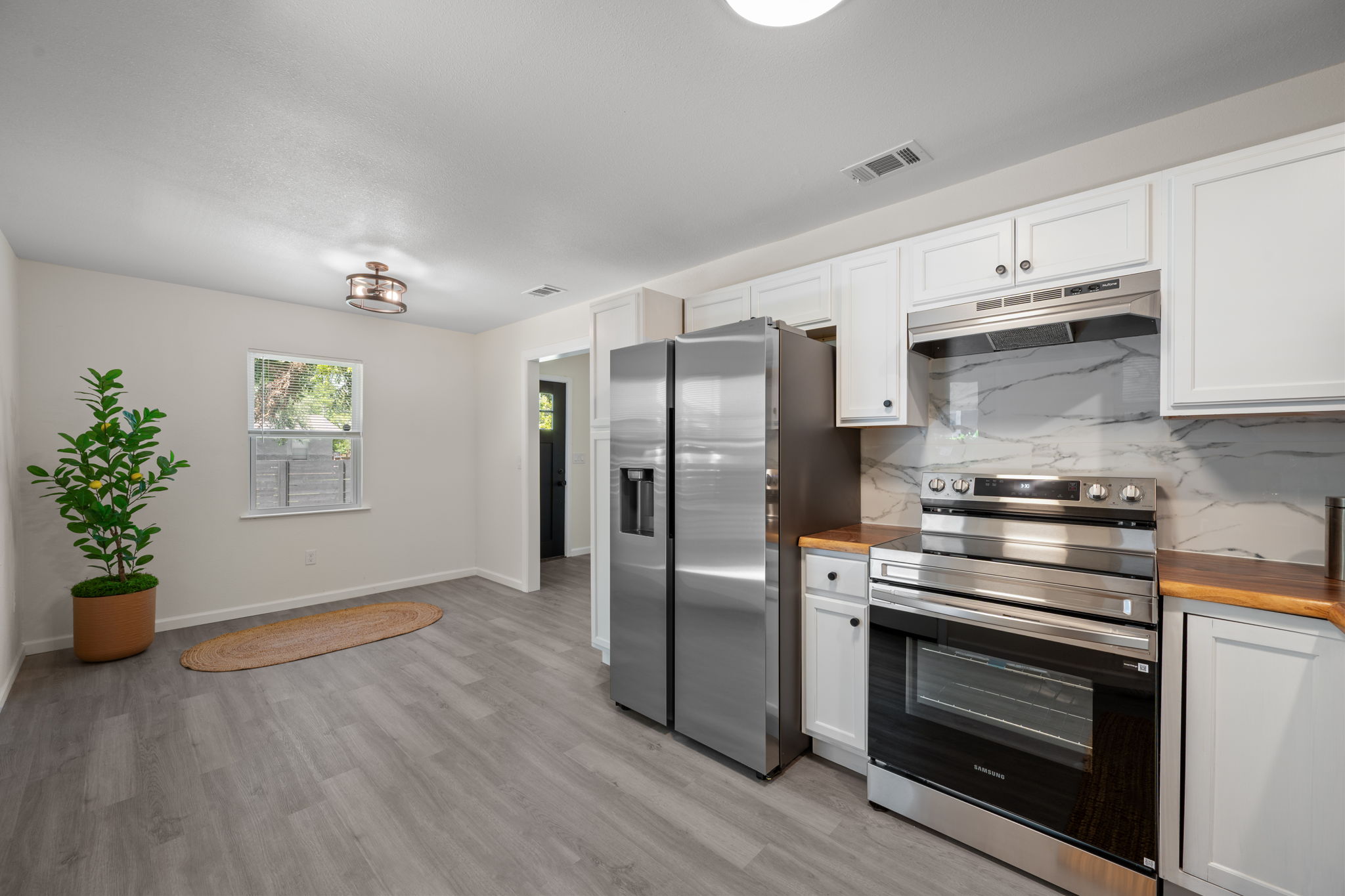 4711 Bandera Road Austin, TX 78721 - Photo 4 of 22 a kitchen with stainless steel appliances a stove a microwave and a hard wood floors