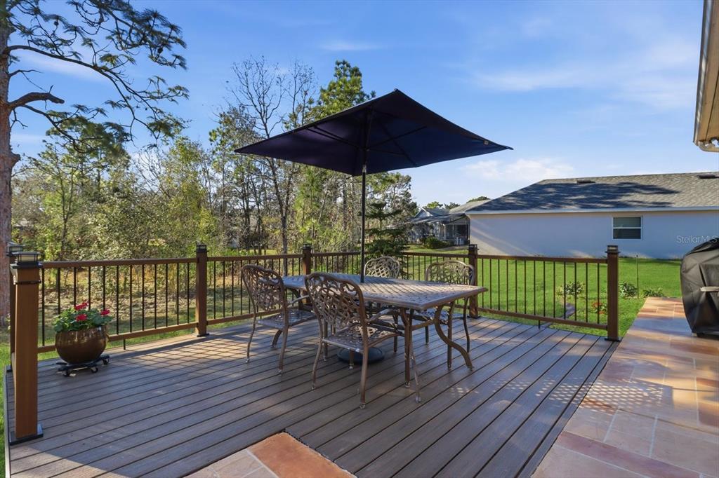 6 Carnation Court Homosassa, FL 34446 - Photo 40 of 48 a view of deck with table and chairs under an umbrella with wooden floor