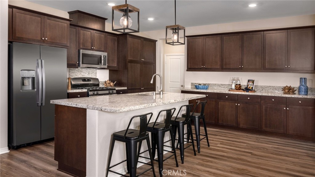 5222 Chaps Way Hemet, CA 92545 - Photo 4 of 15 a kitchen with stainless steel appliances granite countertop a sink a microwave refrigerator and chairs