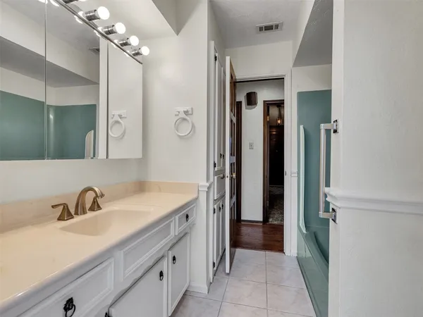 a spacious bathroom with a glass shower door and a sink