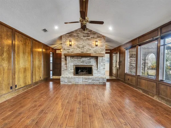 a view of an empty room with glass door and wooden floor