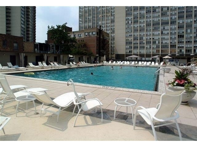 655 West Irving Park Road, Unit 4015 Chicago, IL 60613 - Photo 11 of 14 a patio with table and chairs and potted plants