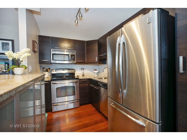 655 West Irving Park Road, Unit 4015 Chicago, IL 60613 - Photo 4 of 14 a kitchen with granite countertop a refrigerator stove and sink