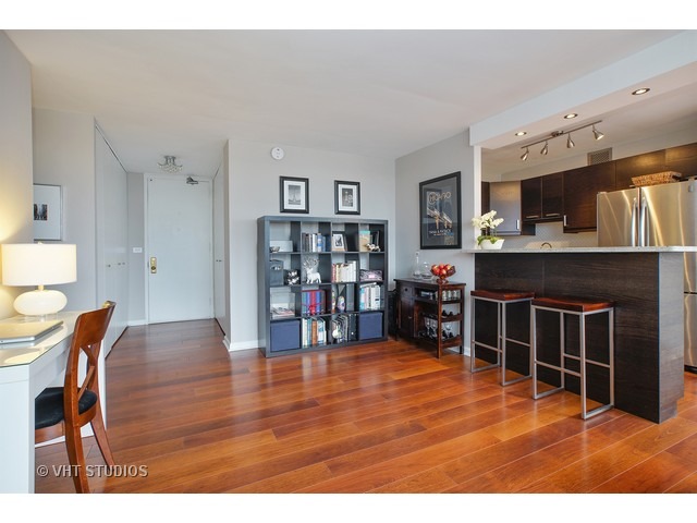 655 West Irving Park Road, Unit 4015 Chicago, IL 60613 - Photo 6 of 14 a living room with stainless steel appliances furniture a fireplace and a flat screen tv