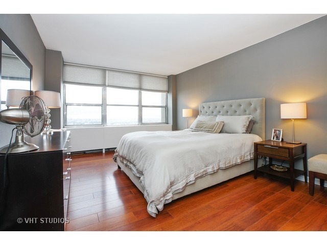 655 West Irving Park Road, Unit 4015 Chicago, IL 60613 - Photo 7 of 14 a bedroom with a bed and wooden floor