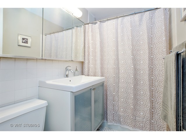 655 West Irving Park Road, Unit 4015 Chicago, IL 60613 - Photo 8 of 14 a bathroom with a sink and a mirror