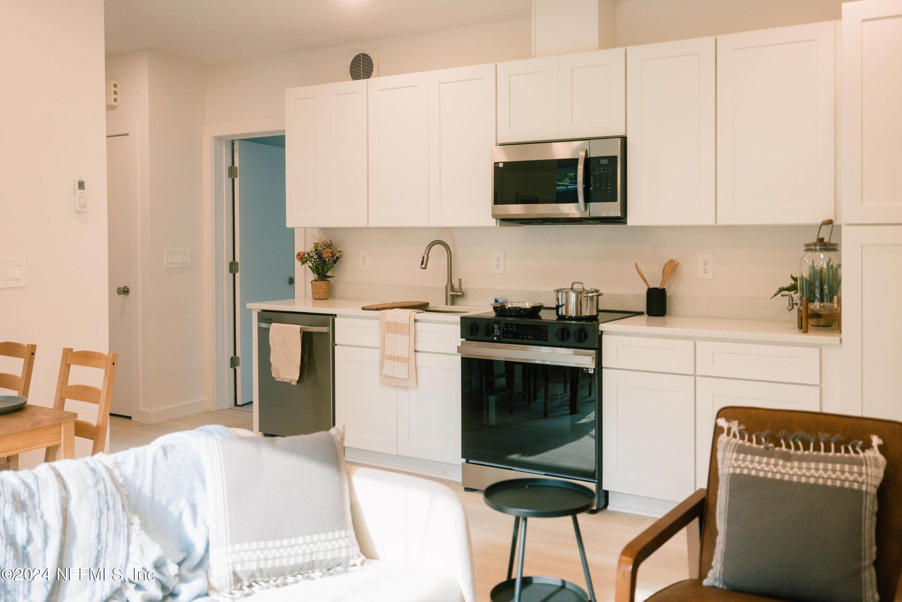 673 Julia Street St. Augustine, FL 32084 - Photo 8 of 21 a kitchen with stainless steel appliances a stove a sink cabinets and a refrigerator