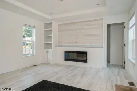 an empty room with windows and fireplace