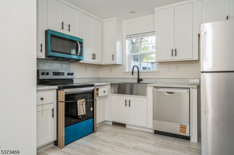 195 West Main Street, Unit 22 Chester, NJ 07930 - Photo 6 of 23 a kitchen with white cabinets and stainless steel appliances