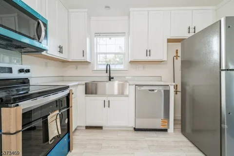 a kitchen with stainless steel appliances a stove a refrigerator and cabinets