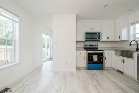 a kitchen with stainless steel appliances a stove top oven a sink a counter space and cabinets