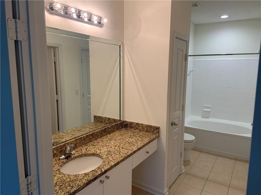 10 Perimeter Summit Boulevard, Unit 1404 Brookhaven, GA 30319 - Photo 16 of 39 a bathroom with a granite countertop sink and a mirror a toilet