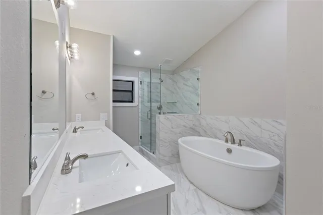 a bathroom with a tub sink and mirror