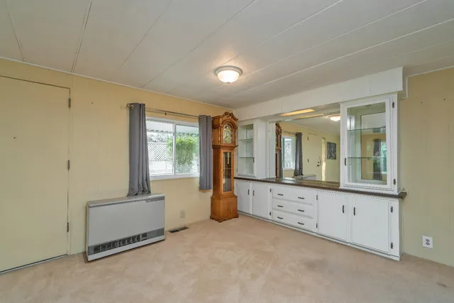 an empty room with windows cabinet and mirror
