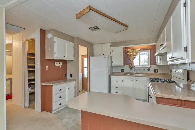 a kitchen with cabinets appliances a sink and a window