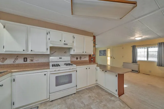 a kitchen with cabinets appliances a sink and a window
