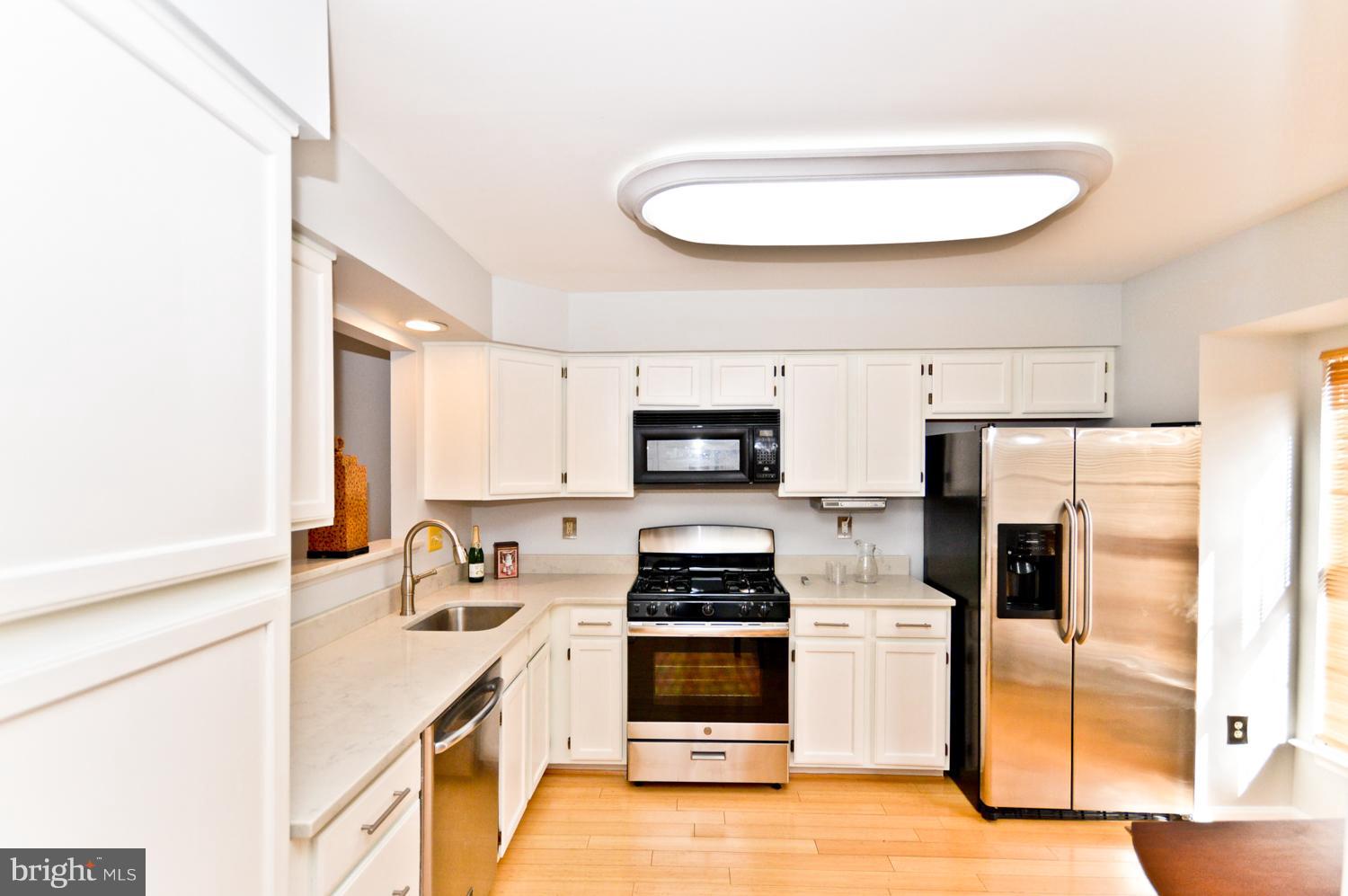 9923 Raintree Way Clinton, MD 20735 - Photo 4 of 30 a kitchen with stainless steel appliances a stove a sink and a refrigerator