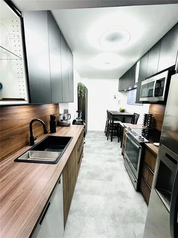a kitchen with stainless steel appliances granite countertop a sink and stove
