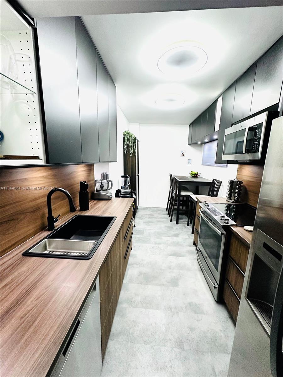 a kitchen with stainless steel appliances granite countertop a sink and stove