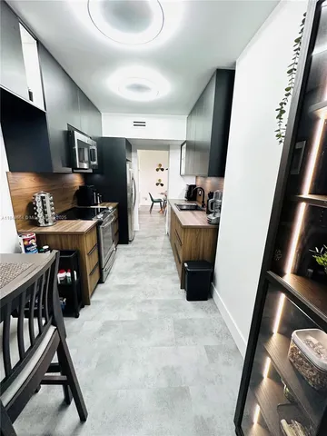 a view of a hallway with wooden floor and furniture