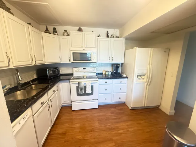 a kitchen with white cabinets and white appliances