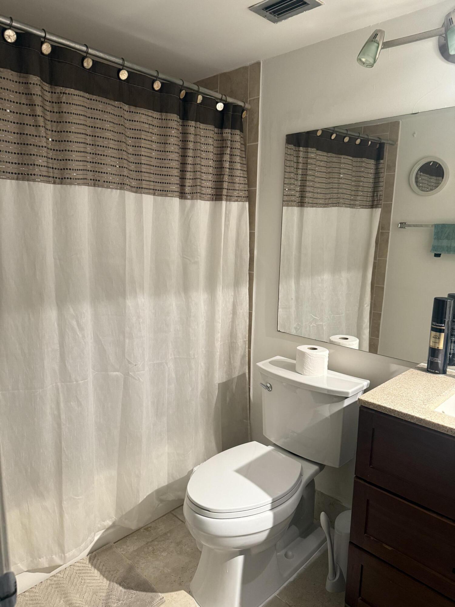 246 Preston F, Unit 246 Boca Raton, FL 33434 - Photo 6 of 10 a bathroom with a granite countertop sink toilet and shower