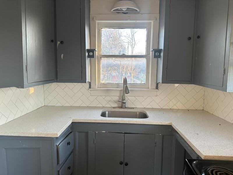 a kitchen with a sink cabinets and a large window