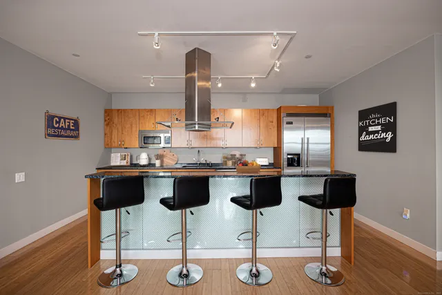 a kitchen with granite countertop a counter space and chairs in it