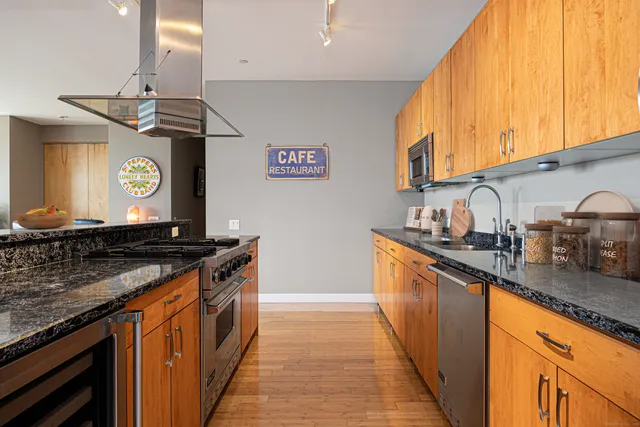 a kitchen with stainless steel appliances granite countertop a sink and a stove